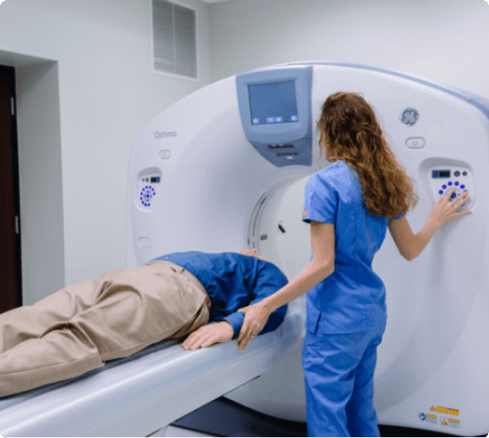 Medical technician assisting a patient undergoing a CT scan procedure.
