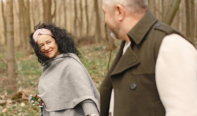 A happy, healthy couple holding hands on a nature trail